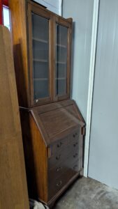 Vintage wooden display cabinet with glass doors and brass handles.