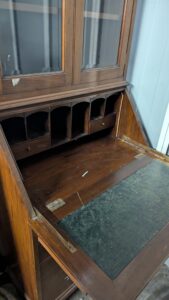 Vintage wooden display cabinet with glass doors and brass handles.
