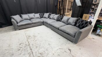 Grey fabric corner sofa with matching cushions, spacious seating, ideal for modern living rooms in Northern Ireland. Perfectly refurbished for comfort and style.