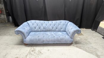 Blue velvet 2-seater sofa with rolled arms and tufted detailing, perfect for classic or vintage living rooms in Northern Ireland. Refurbished by Maria Furniture Ltd.