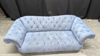 Luxurious light blue fabric 3-seater sofa with button-tufted design and rounded armrests.