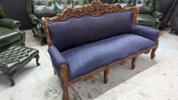 Refurbished Victorian carved wooden sofa with blue fabric, ornate woodwork, and curved arms, ideal for vintage and traditional home decor.