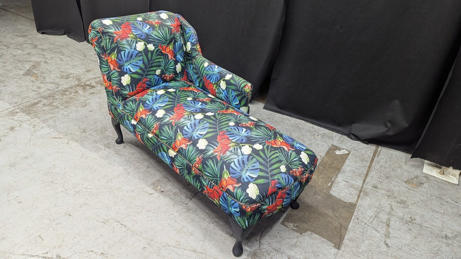 Tropical chaise lounge. Vibrant tropical print chaise lounge with floral and leaf patterns, black wooden legs, perfect for a stylish, refurbished furniture piece in Northern Ireland.