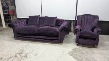 Purple velvet 2-seater sofa and matching armchair, classic style with plush cushions and wooden legs. Perfect for a stylish living room.