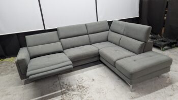 Corner sofa in grey fabric with adjustable recliner sections.
