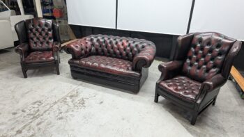 Chesterfield 2-seater and armchairs in burgundy leather with deep button tufting and rolled arms.