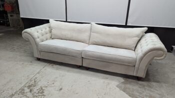 Cream Chesterfield 3-seater sofa with tufted arms.
