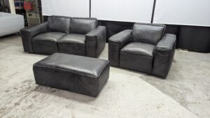 Modern black leather sofa set with matching ottoman.
