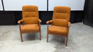 Vintage brown armchairs with wooden armrests and legs.