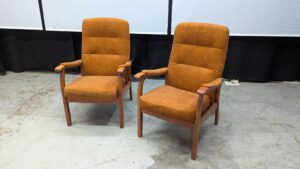 Vintage brown armchairs with wooden armrests and legs.