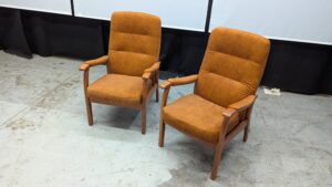 Vintage brown armchairs with wooden armrests and legs.