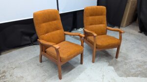 Vintage brown armchairs with wooden armrests and legs.