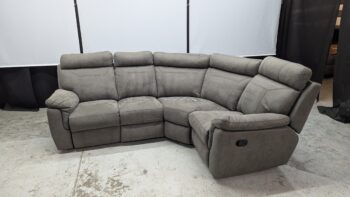 Corner sofa in grey fabric with recliner feature.