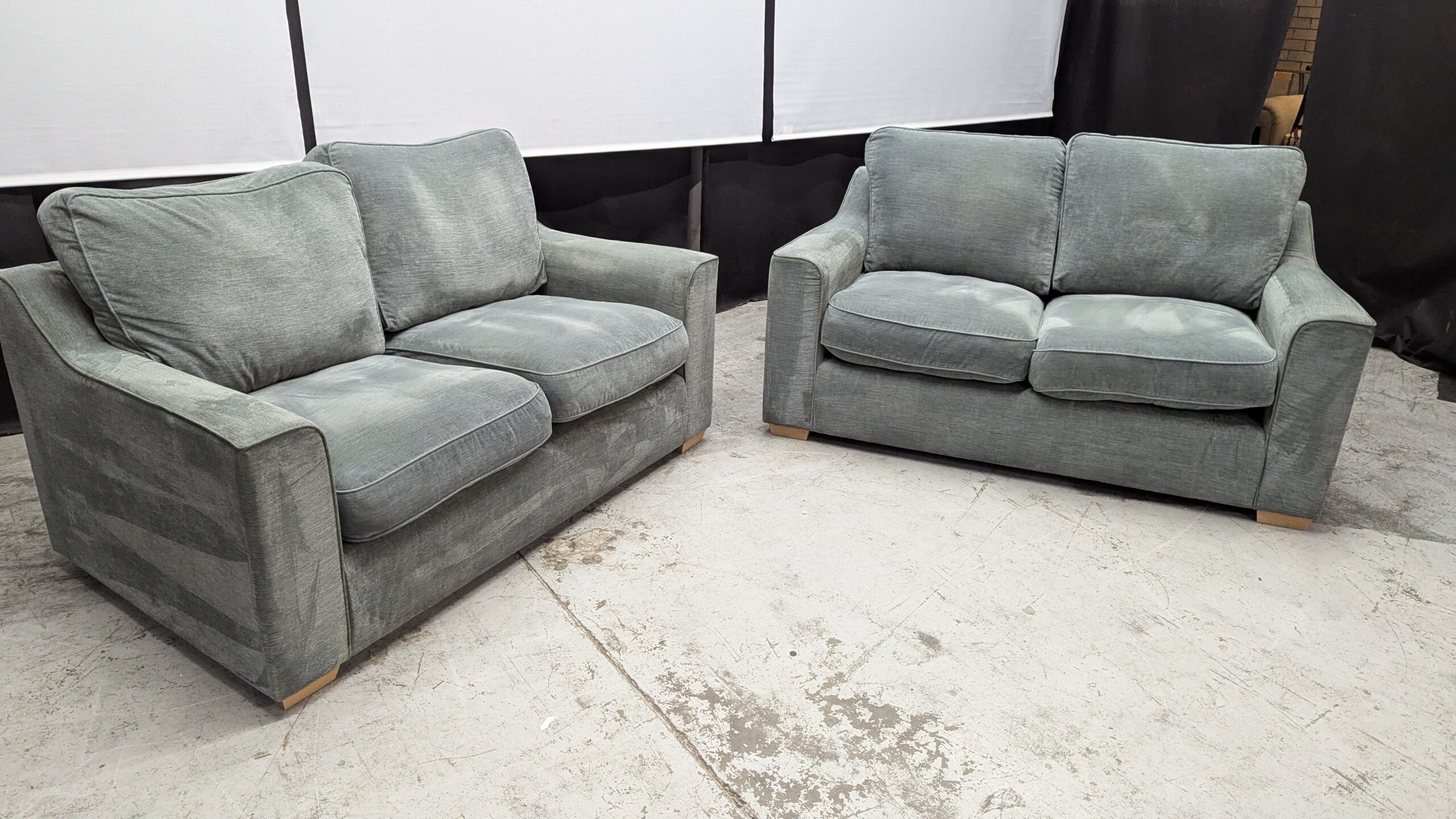 Modern grey fabric 2-seater sofa Two grey fabric 2-seater sofas with plush cushions and wooden legs.