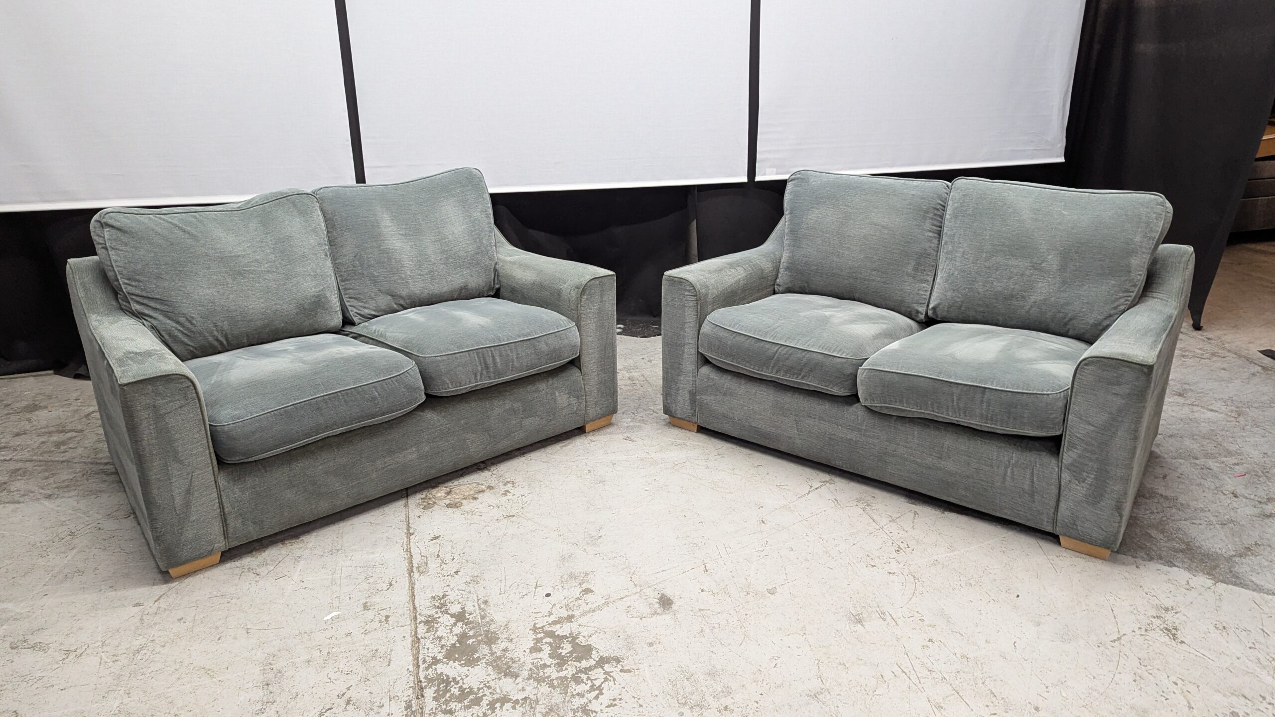 Modern Grey 2-Seater and 3-Seater Sofas Two grey fabric sofas, one 2-seater and one 3-seater, with plush cushions and wooden legs.